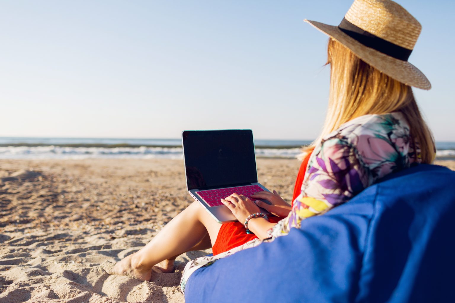 Mooie jonge vrouw die met laptop aan het tropische strand werkt 1536x1024